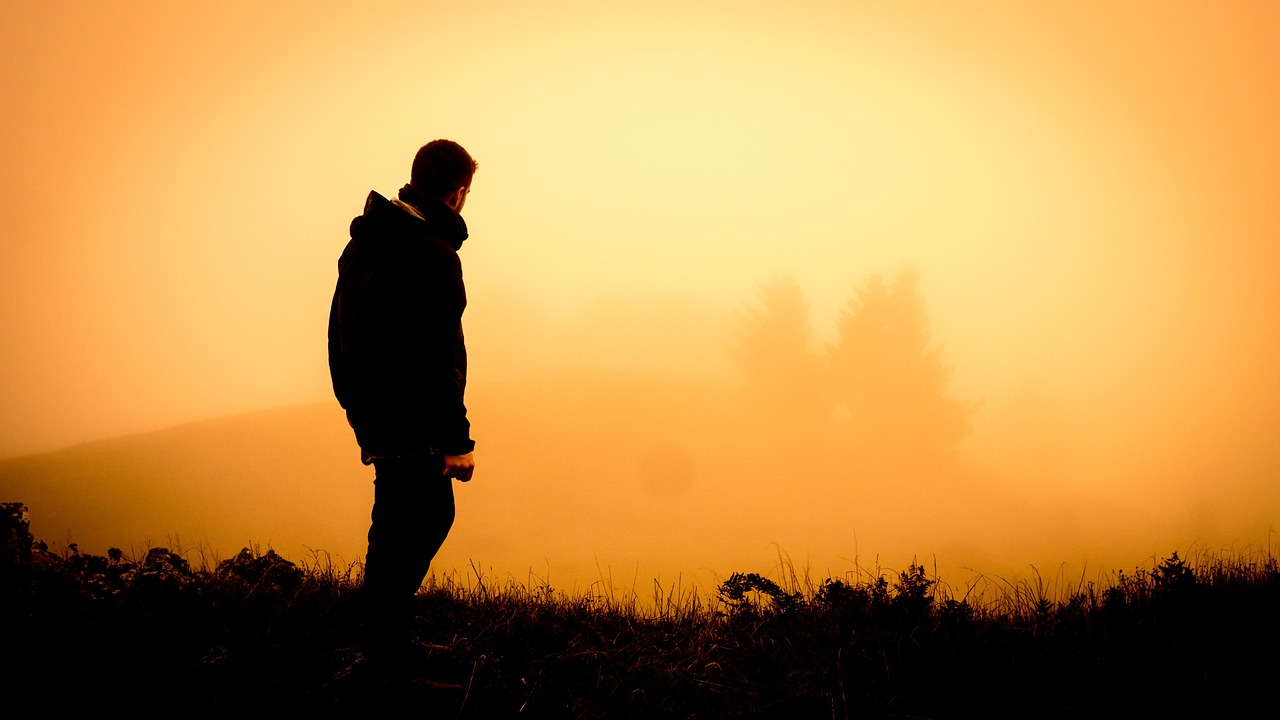 Man staring into the distant fog at dusk, showing what women find attractive in men