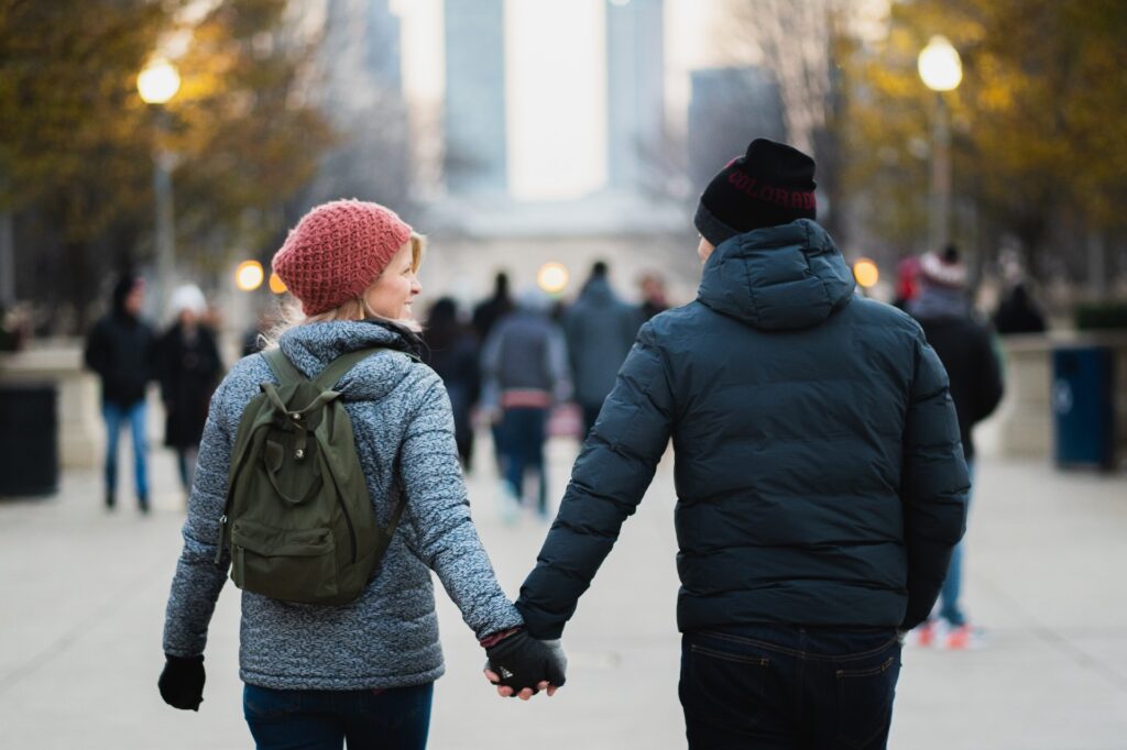 Man and woman holding hands in winter, showcasing unique and romantic first date ideas that can impress him