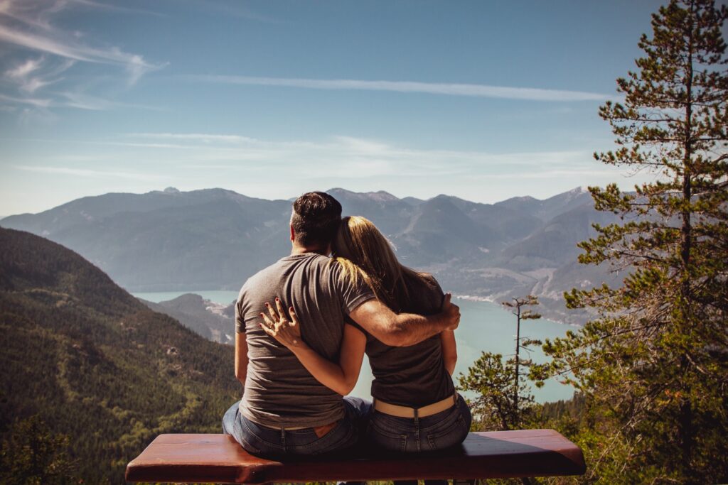 Couple sitting together overlooking a valley, symbolizing understanding body preferences and building confidence in relationships