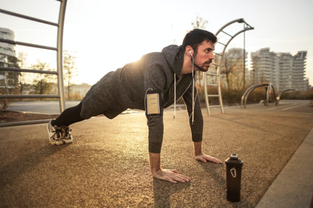 Man doing pushups in a park at sunrise, illustrating morning workout routines