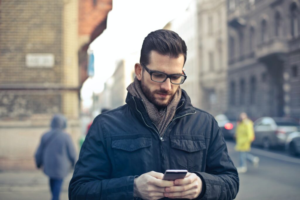 Man looking at his phone, representing engaging text conversations