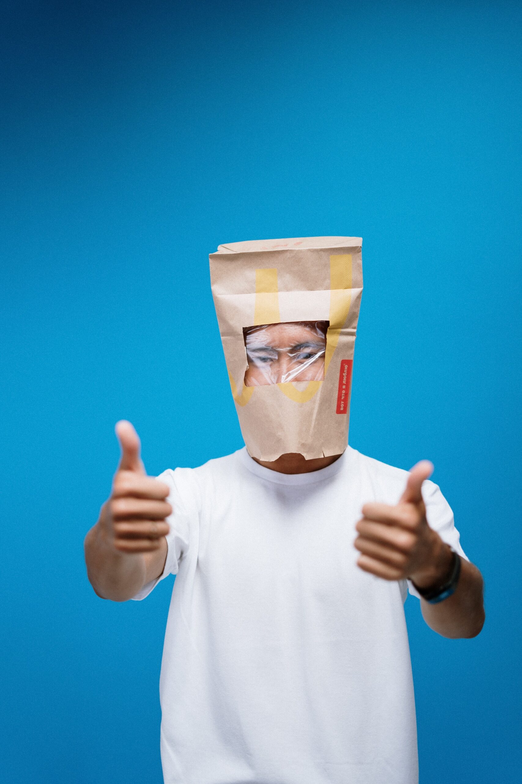 Man with paper bag on head with thumbs up